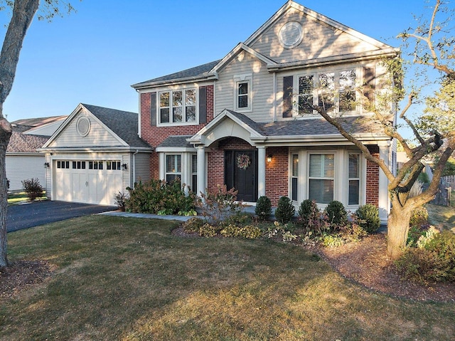 view of front of home with a front lawn, an attached garage, brick siding, and driveway