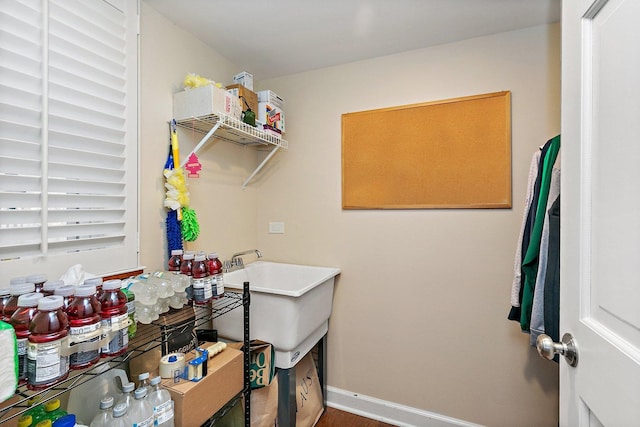 laundry room with baseboards and a sink