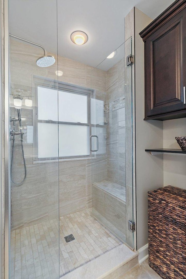 bathroom featuring a shower stall and baseboards