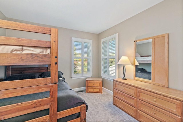 bedroom featuring visible vents, baseboards, and light carpet