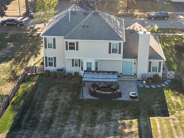 back of property with a fenced backyard, a lawn, a chimney, and a patio