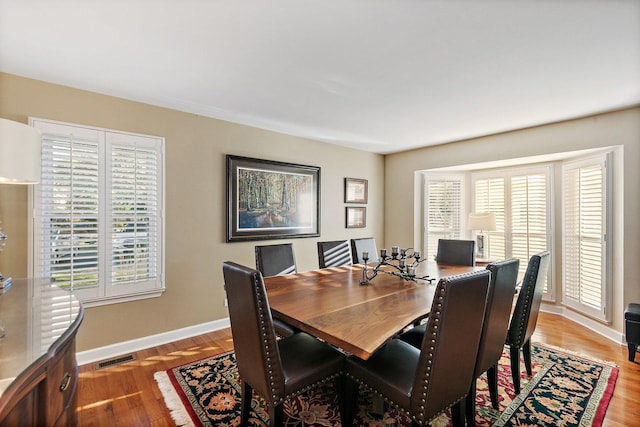 dining room with visible vents, baseboards, and wood finished floors