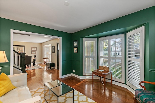 living area with hardwood / wood-style flooring, stairway, and baseboards