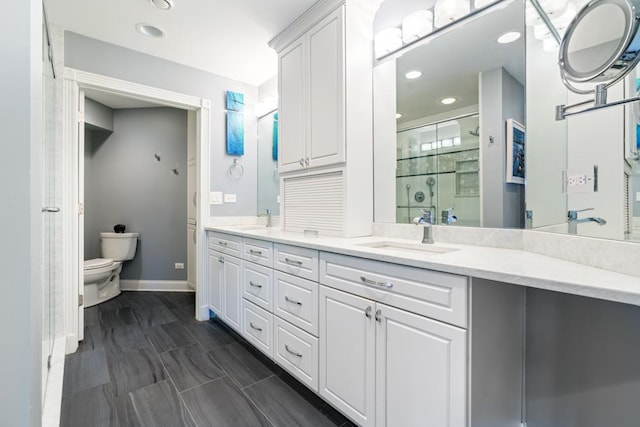 bathroom with a shower stall, toilet, double vanity, and a sink