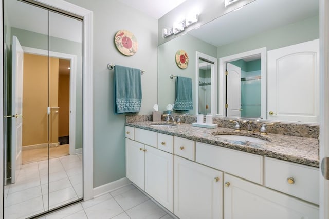 full bath with tile patterned floors, double vanity, a shower with door, and a sink