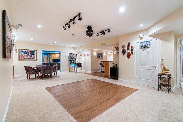 interior space featuring track lighting, indoor bar, baseboards, light colored carpet, and recessed lighting