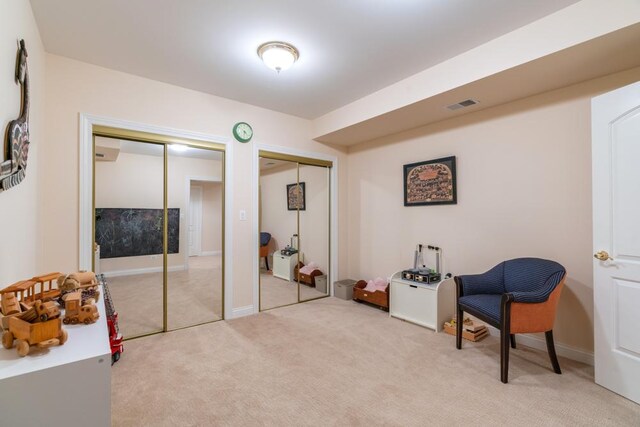 living area with light carpet and visible vents