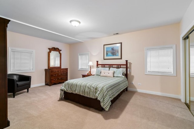 bedroom with visible vents, light carpet, and baseboards