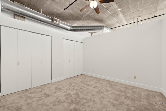 unfurnished bedroom with baseboards, multiple closets, and carpet floors