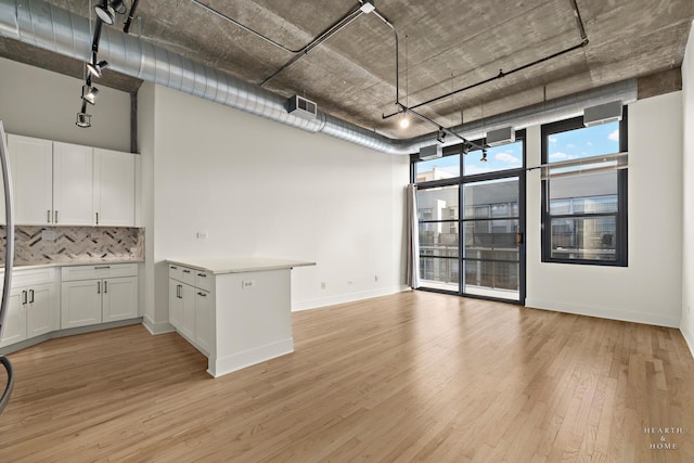 kitchen featuring visible vents, light wood-style flooring, decorative backsplash, light countertops, and white cabinetry