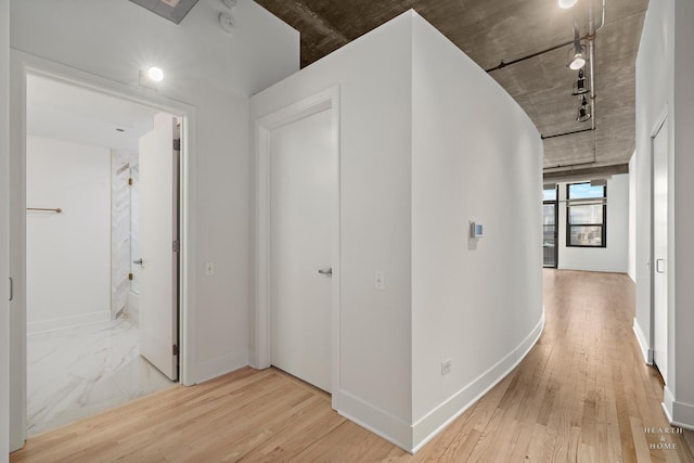 hallway featuring wood finished floors and baseboards