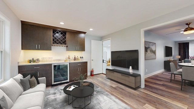 living room with baseboards, recessed lighting, a bar, wine cooler, and light wood-style floors