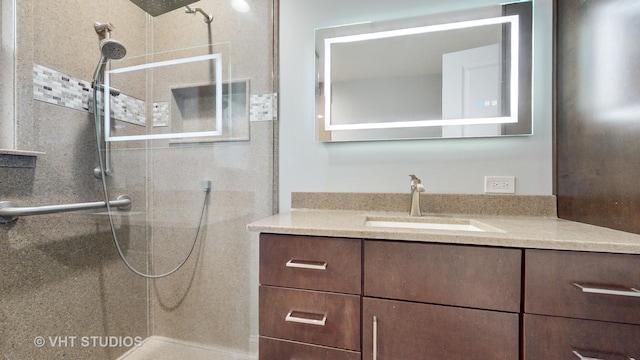 full bath featuring a tile shower and vanity