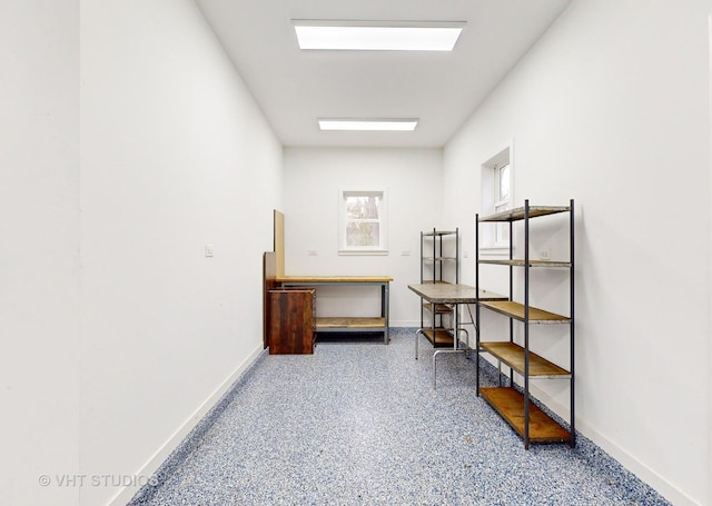 interior space featuring speckled floor and baseboards