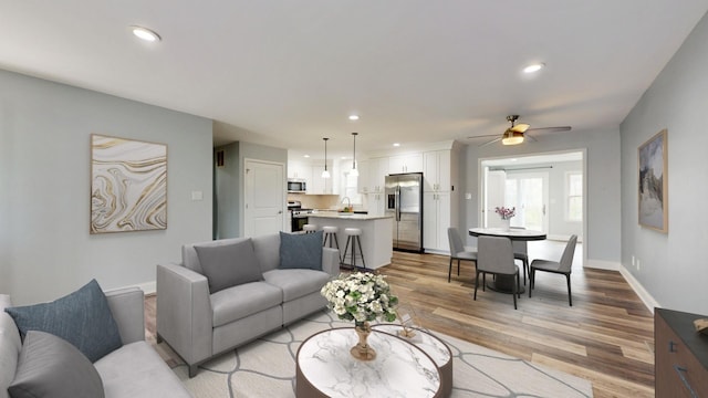 living area with light wood-style flooring, recessed lighting, baseboards, and ceiling fan