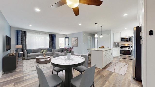 dining space featuring recessed lighting, baseboards, and light wood-style floors