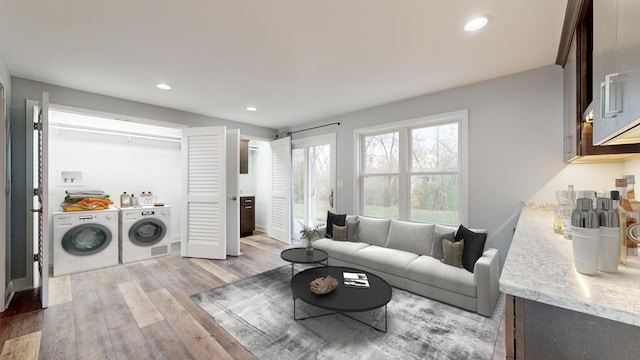 living room featuring washing machine and clothes dryer, recessed lighting, and light wood-style floors