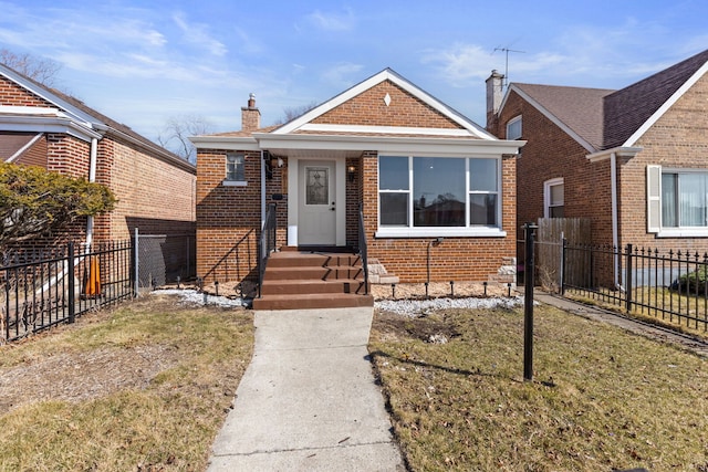 bungalow-style house with brick siding, a chimney, and fence