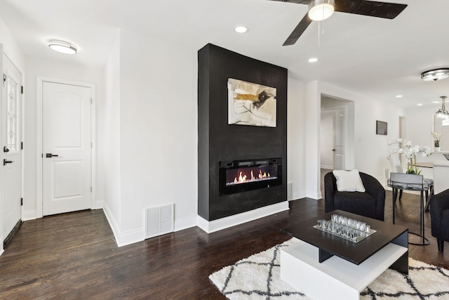 living room featuring wood finished floors, a fireplace, and visible vents