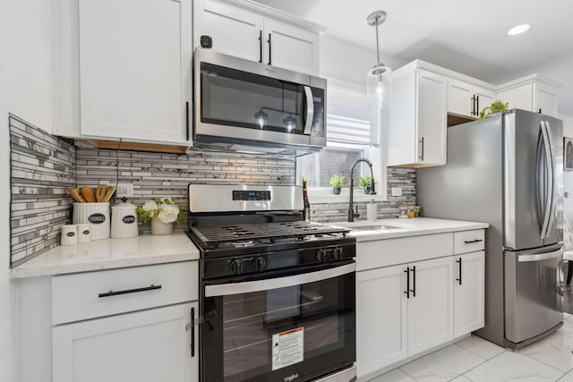 kitchen featuring a sink, marble finish floor, appliances with stainless steel finishes, and white cabinetry