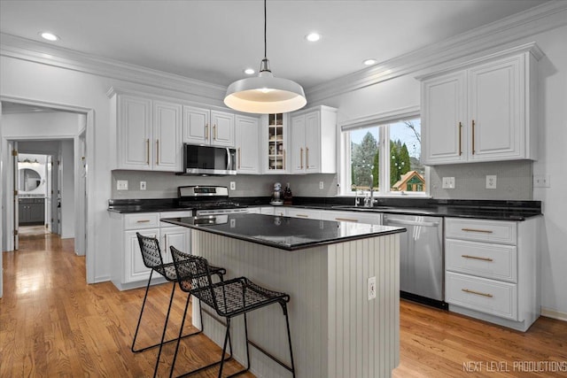 kitchen featuring light wood-type flooring, stainless steel appliances, crown molding, and white cabinetry