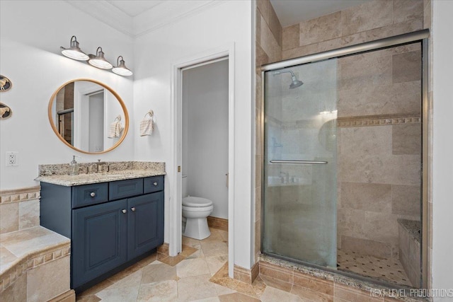 full bathroom featuring vanity, a shower stall, toilet, and crown molding