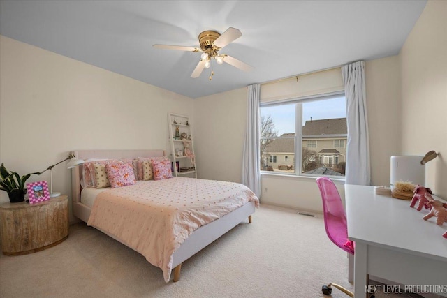 carpeted bedroom with visible vents and ceiling fan