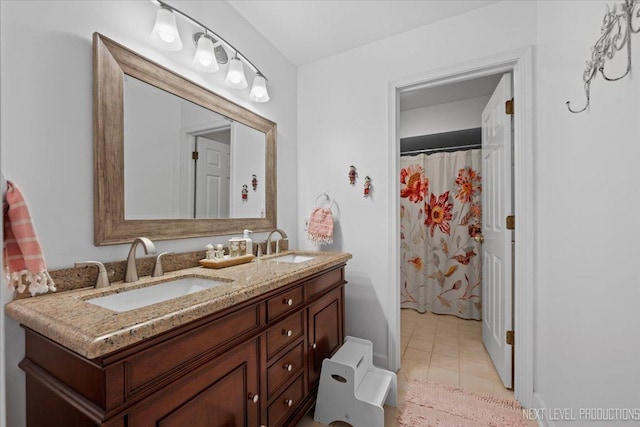 full bath with double vanity, tile patterned floors, and a sink