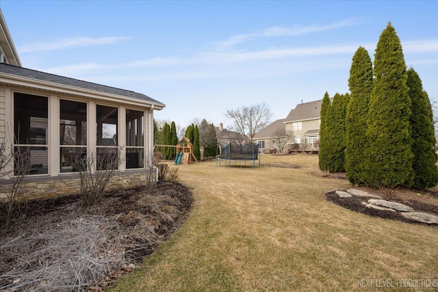 view of yard featuring a playground, a trampoline, and a sunroom