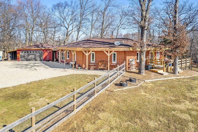 view of front of house with fence, driveway, an attached garage, a front lawn, and brick siding