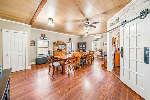 dining area featuring a barn door, plenty of natural light, and wood finished floors