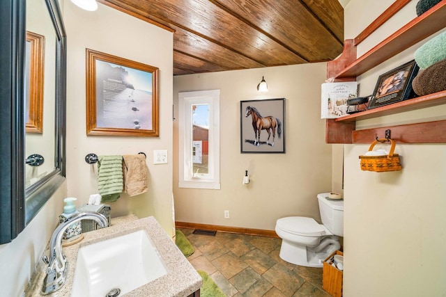 half bath with visible vents, toilet, stone tile floors, baseboards, and wood ceiling