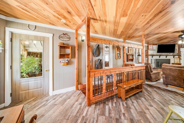 dining room featuring a fireplace, wood ceiling, wood finished floors, and ceiling fan