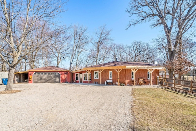 view of front facade featuring brick siding, fence, a garage, and driveway