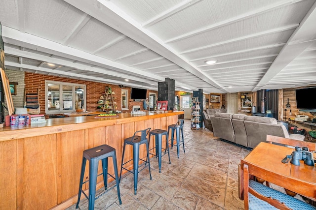 bar with indoor wet bar and brick wall