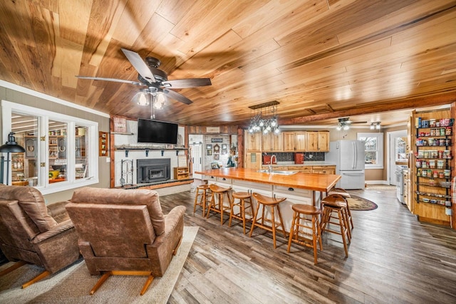 living room featuring dark wood-type flooring, wood ceiling, and a ceiling fan