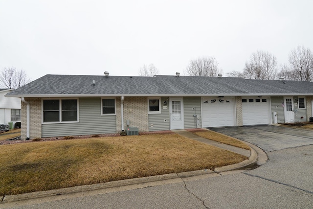 single story home featuring driveway, brick siding, and an attached garage