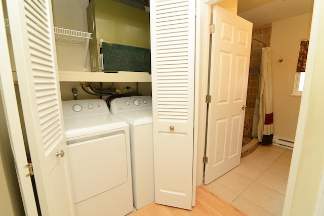 washroom featuring light tile patterned flooring, laundry area, independent washer and dryer, and a baseboard radiator