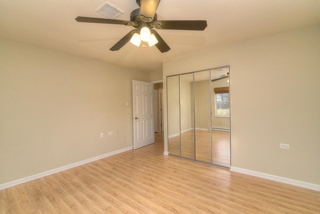 unfurnished bedroom featuring light wood-type flooring, baseboards, a closet, and visible vents