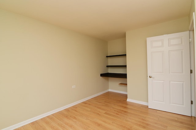 unfurnished bedroom with light wood-style flooring and baseboards