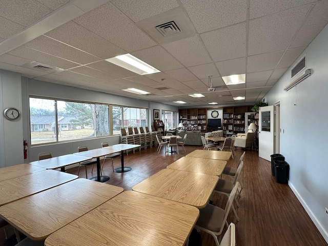 unfurnished dining area with visible vents, baseboards, and wood finished floors