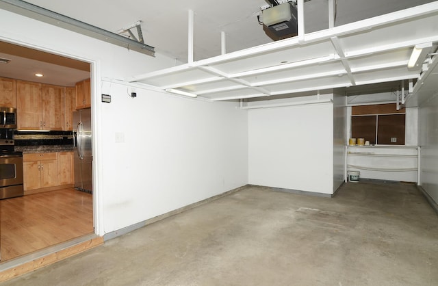 garage with visible vents, stainless steel fridge, baseboards, and a garage door opener