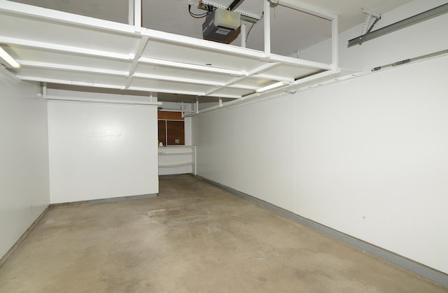 garage featuring a garage door opener and baseboards