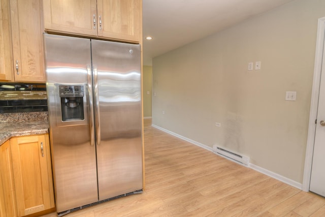 kitchen with light wood-type flooring, a baseboard radiator, stainless steel fridge, and baseboards