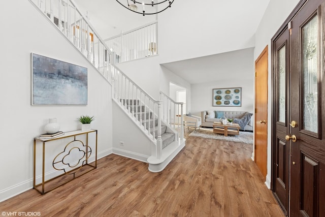 entryway with stairs, wood finished floors, and baseboards