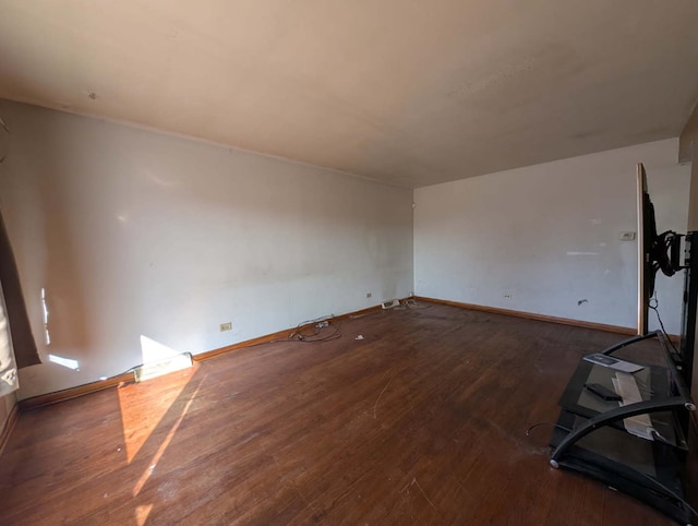 empty room featuring baseboards and wood finished floors