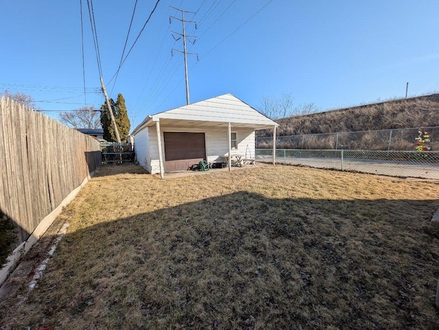 view of yard featuring an outbuilding, a detached garage, and a fenced backyard