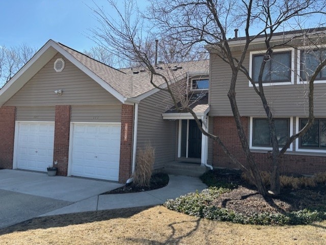 view of front of property with a garage, brick siding, and concrete driveway