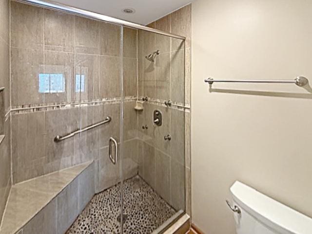 bathroom with a shower stall and toilet