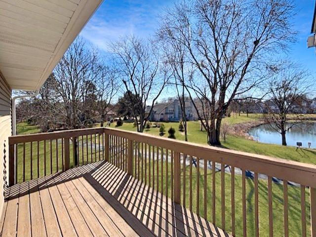 wooden terrace with a yard and a water view